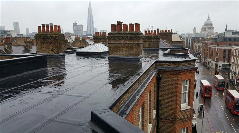 A flat roof with the London skyline behind